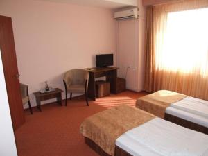 Habitación de hotel con 2 camas y escritorio con ordenador en PLAISIR, en Ploieşti