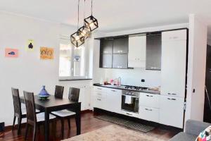 a kitchen with a table and a kitchen with white cabinets at City View Living in Milan