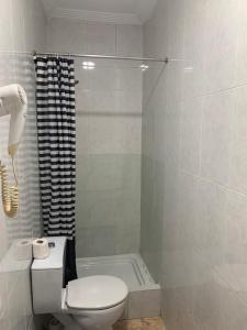 biała łazienka z toaletą i prysznicem w obiekcie Hostal Alcobia w Sewilli