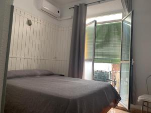 sypialnia z łóżkiem i dużym oknem w obiekcie Hostal Alcobia w Sewilli