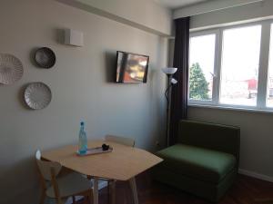 ein Wohnzimmer mit einem Tisch und einem grünen Stuhl in der Unterkunft Chez Moi Bolhão in Porto