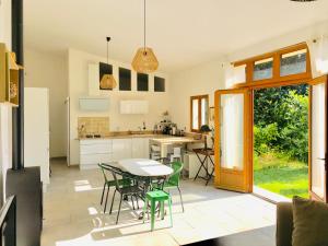 - une cuisine et une salle à manger avec une table et des chaises dans l'établissement Maison de Campagne by La Boîte En Plus, à Senlis