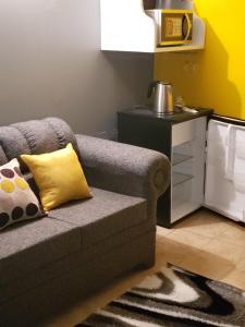 a living room with a gray couch and a yellow pillow at Ocean View - 1Bedroom overlooking the sea in Cane River