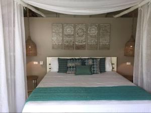 
a bed room with a bed with white sheets and pillows at Mahona Boutique Hotel in Las Terrenas
