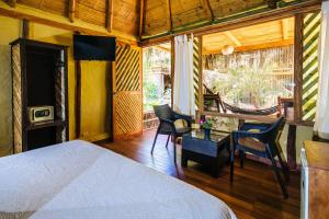 a bedroom with a bed and a table and chairs at Kimbas Bungalows Mancora in Máncora +67 photos