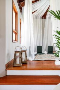 a room with two chairs and white curtains at Casa Paradisíaca na Lagoa da Conceição in Florianópolis