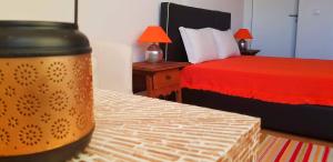 - une chambre avec un lit doté d'un couvre-lit rouge et d'une table dans l'établissement Charme de Monsaraz II, à Monsaraz