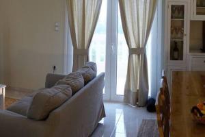 uma sala de estar com um sofá e uma grande janela em Michaela em Gázion