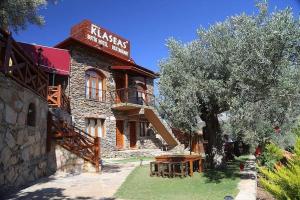duży kamienny budynek z drzewem przed nim w obiekcie Şirince Klaseas Hotel&Restaurant w mieście Selçuk