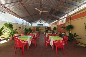 a restaurant with red tables and red chairs at Hotel Olimpico in Barranquilla