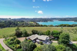 an aerial view of a house on a hill next to a lake at Waiheke Island Vineyard Holiday Houses in Surfdale