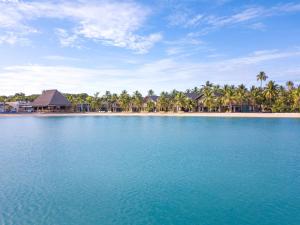 a view of a beach with palm trees and blue water at Plantation Island Resort in Malolo Lailai