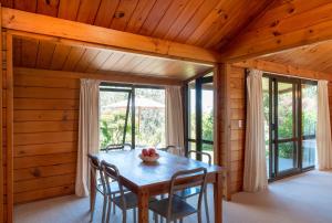 a dining room with a table and chairs at Waiheke Island Vineyard Holiday Houses in Surfdale