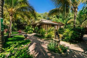 a resort with palm trees and a building at Kimbas Bungalows Mancora in Máncora
