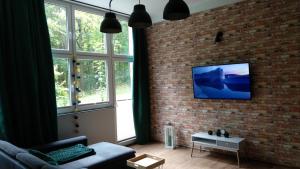 salon z kanapą i ścianą z cegły w obiekcie Apartament 5 przy Parku Leśnym w Polanicy Zdroju