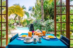 a table with a blue table cloth and food on it at Kimbas Bungalows Mancora in Máncora