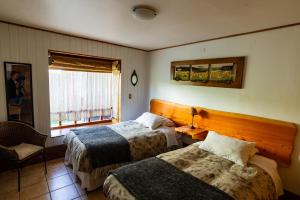a hotel room with two beds and a window at B&B HMüller in Pucón