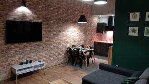salon z telewizorem na murze w obiekcie Apartament 5 przy Parku Leśnym w Polanicy Zdroju