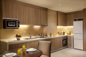 a kitchen with a table and a white refrigerator at Somerset Wusheng Wuhan in Wuhan