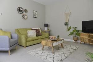uma sala de estar com um sofá verde e uma mesa de centro em 10B Old green Chamber City center apartment, spacious and free parking! em St Ives