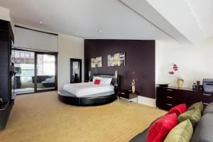 Un dormitorio grande con una cama y un sofá. en Edge 21, en Big White