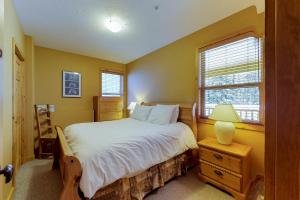 a bedroom with a large bed and a window at Silver Tip 6 in Big White