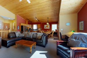 a living room with leather couches and a dining room at Silver Tip 6 in Big White
