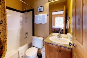 a bathroom with a toilet and a sink and a shower at Silver Tip 6 in Big White +25 photos