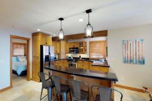 cocina con encimera y sillas en una habitación en Rockridge 375 Snow Escape, en Big White