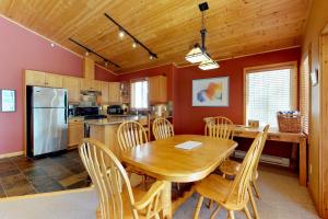 a kitchen with a wooden dining room table and chairs at Silver Tip 6 in Big White