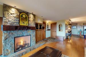 a living room with a large stone fireplace at North 9 in Big White