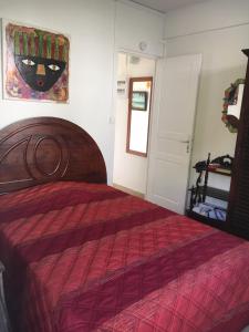 a bedroom with a bed with a red comforter at Villa les Palmiers in Les Trois-Îlets