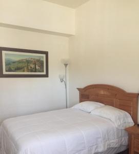 a bedroom with a white bed and a picture on the wall at Whitney Portal Hotel And Hostel in Lone Pine