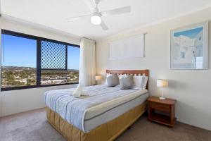 a bedroom with a large bed and a large window at Langley Park Apartments in Maroochydore
