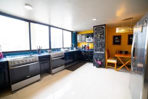 una grande cucina con elettrodomestici neri e pareti gialle di Caravansaro Penthouse Polanco a Città del Messico