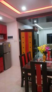 a kitchen with a table and chairs and a refrigerator at Tagaytay Suite 2 in Tagaytay