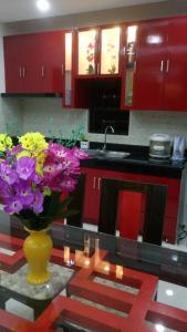 a kitchen with a vase of purple flowers on a table at Tagaytay Suite 2 in Tagaytay