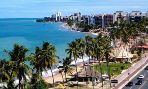 vistas a una playa con palmeras y edificios en Apartamento Beira Mar Maceió ll, en Maceió