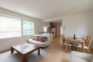 a living room with a couch and a table at Sakura Apartments in Kutchan