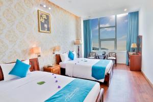 a hotel room with two beds and a window at Cong Doan Thanh Binh Hotel in Danang