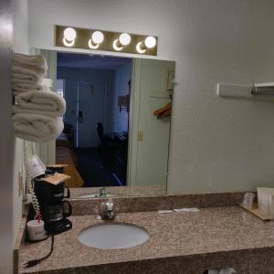baño con lavabo y espejo grande en Travel Inn, en Delaware