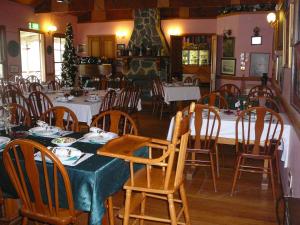 uma sala de jantar com mesas e cadeiras num restaurante em Bestbrook Mountain Farmstay em Maryvale