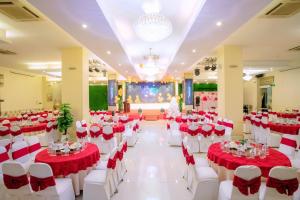 a banquet hall with red and white tables and chairs at Cong Doan Thanh Binh Hotel in Danang