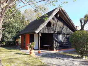 a small log cabin with a thatched roof at LA CABAÑA in Atlántida