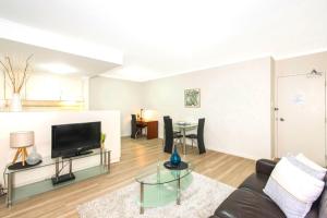 a living room with a couch and a tv at Perth West End Apartment 601 in Perth