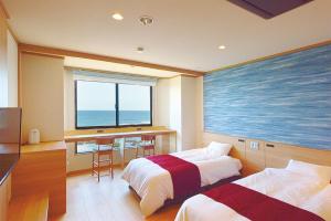a hotel room with two beds and a view of the ocean at Oarai Hotel Annex Gyoraian in Oarai