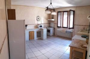 uma cozinha com piso em azulejo branco em Maison familiale à Haybes em Haybes