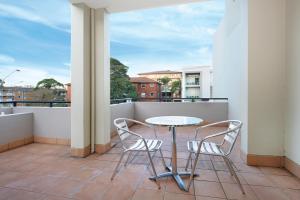 einen Balkon mit einem Tisch und 2 Stühlen in der Unterkunft Wollongong Serviced Apartments in Wollongong