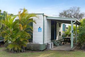 a small white house with a table in front of it at Discovery Parks - Ballina in Ballina