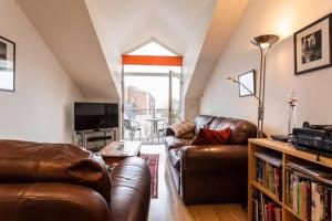 uma sala de estar com dois sofás de couro e uma televisão em Cruisers Haven em Southampton